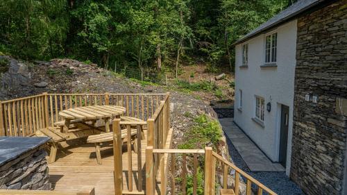 a wooden deck with a picnic table next to a building at Hill Of Oaks in Windermere