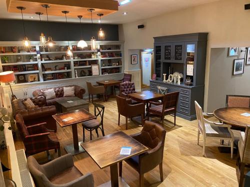 a restaurant with tables and chairs in a room at The Plough in Alnwick