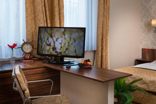 a hotel room with a desk with a television on it at Golden Ball Club in Győr