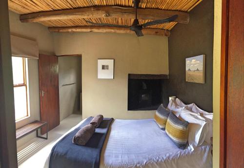 a bedroom with a bed with pillows on it at River View Cottages in Calitzdorp