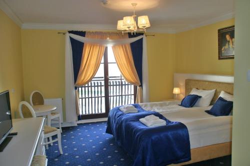 En eller flere senge i et værelse på Hotel Supraśl