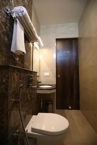 a bathroom with a toilet and a sink at Mayuraa Residency in Chennai