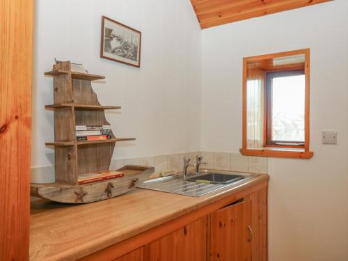cocina con fregadero y encimera de madera en Viola Cottage en Fraserburgh