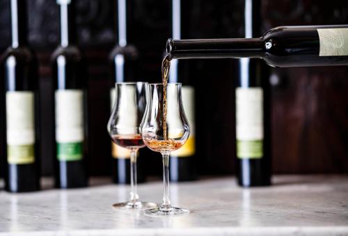 two glasses of wine are being poured at Romantik Hotel & Restaurant Stafler in Vipiteno