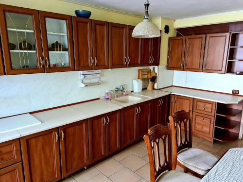 una cocina con armarios de madera y fregadero en три стаен лукс апартамент, en Razgrad