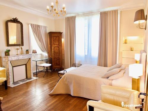 - une grande chambre avec un lit et une cheminée dans l'établissement La Maison Rouge Brocéliande, à Montauban-de-Bretagne