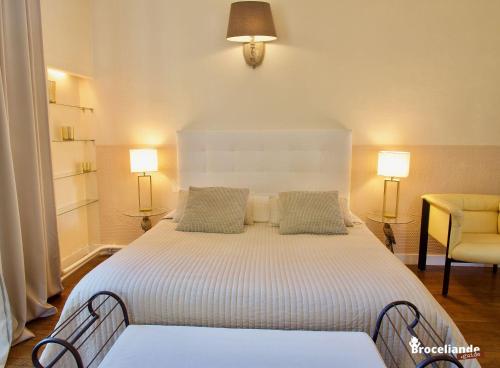 a bedroom with a large white bed with two lamps at La Maison Rouge Brocéliande in Montauban-de-Bretagne