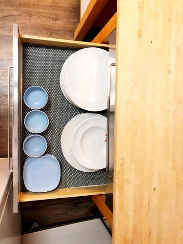 a cupboard filled with white plates and bowls at Lisas Gästehaus in Neckartenzlingen