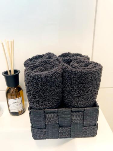 a black towel holder sitting next to a bottle of oils at Lisas Gästehaus in Neckartenzlingen
