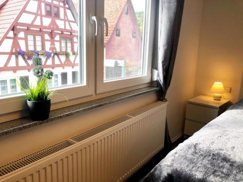a bedroom with a window with a plant on the sill at Lisas Gästehaus in Neckartenzlingen