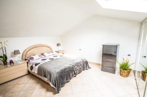 ein Schlafzimmer mit einem großen Bett und Fliesenboden in der Unterkunft Mansarda luminosa in centro a Sanremo in Sanremo