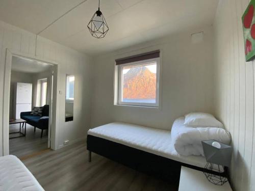 een kleine slaapkamer met een bed en een raam bij Waterfront Senja 2 in Torsken