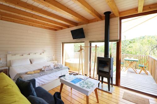 um quarto com uma cama e uma lareira numa casa em Aloia Nature, Alojamiento Forestal em Tui