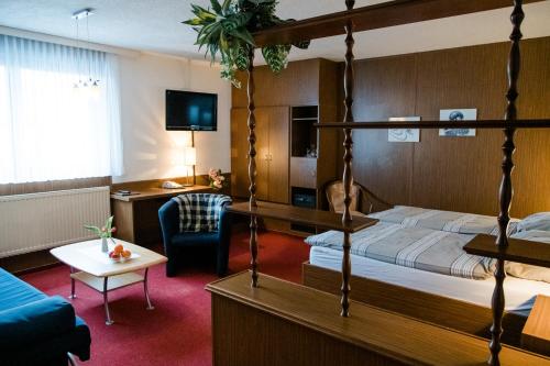 ein Hotelzimmer mit einem Bett und einem Wohnzimmer in der Unterkunft Hotel Müller in Genthin