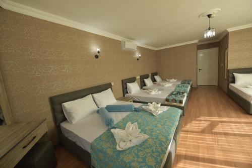 Habitación de hotel con 4 camas seguidas en Omega Luxx Hotel en Estambul