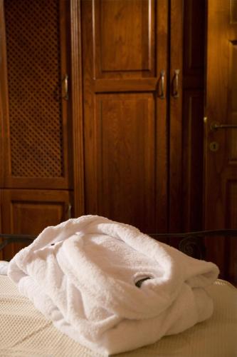 a white towel sitting on top of a bed at Roes Suites in Kato Loutraki