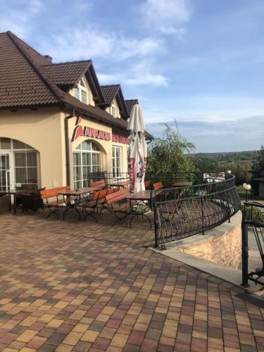 a restaurant with tables and umbrellas on a patio at Hotel Arkadia in Klecza Górna