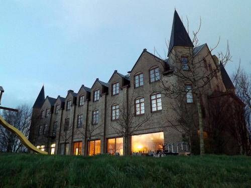 a large brick building with a tower on top at Hotel Hinterland in Alveringem