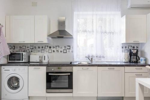 a white kitchen with a sink and a dishwasher at Apartman BUKI **** in Split