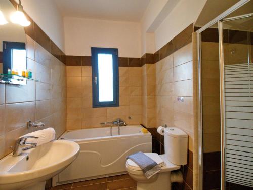 a bathroom with a tub and a sink and a toilet at Villa Anemos, Spartia, Kefalonia in Spartia