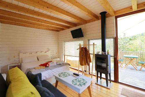 a living room with a couch and a tv in it at Aloia Nature, Alojamiento Forestal in Tui