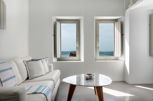 
a living room filled with furniture and a window at Grace Hotel Santorini, Auberge Resorts Collection in Imerovigli
