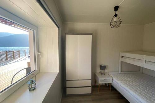 a bedroom with a bed and a window with the ocean at Waterfront Senja 3 in Torsken