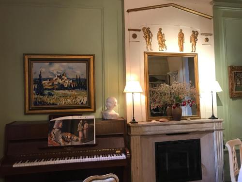 a piano sitting in front of a fireplace at Logis Saint-Flaceau in Le Mans