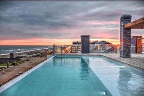 una gran piscina en la parte superior de un edificio con el océano en Los Pinos Pinamar en Pinamar