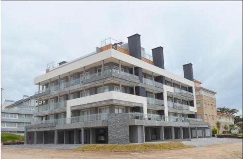 a large apartment building with a lot of windows at Los Pinos Pinamar in Pinamar