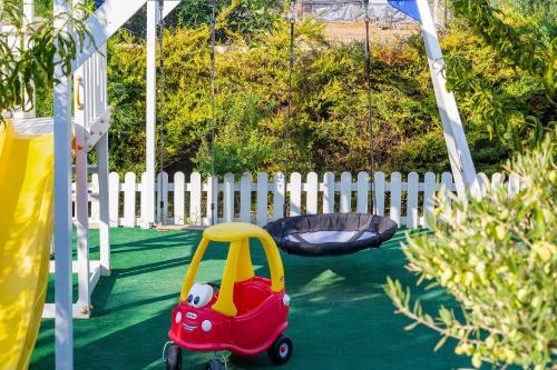 a toy car in a playground with a swing at Villa Green Diamond - Private Heated Pool in Platanes