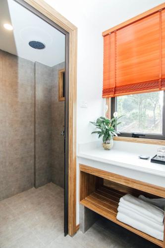 a bathroom with a shower and a sink at Sea Angel Hotel Halong in Ha Long