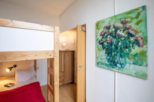 a bedroom with a painting of flowers on the wall at Fürstenhof - Ferienwohnung 106 in Sassnitz