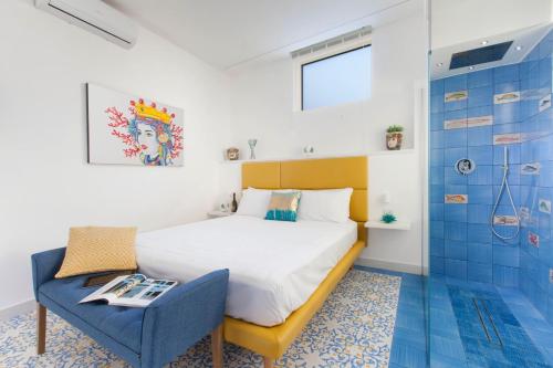 um quarto com uma cama, uma cadeira e um chuveiro em Vivaldo Suite - Fuoro em Sorrento