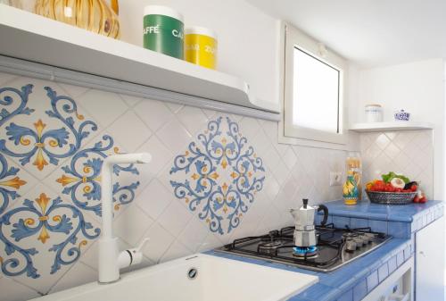 uma cozinha com azulejos azuis e brancos na parede em Vivaldo Suite - Fuoro em Sorrento