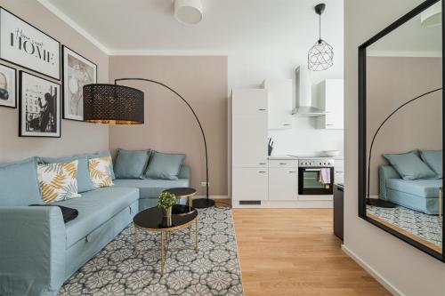 ein Wohnzimmer mit einem blauen Sofa und einem Tisch in der Unterkunft easy flat Margareten Apartments in Wien