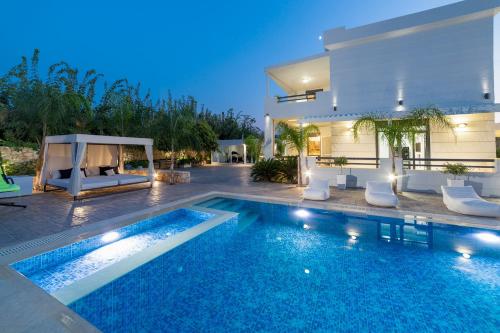 a swimming pool in front of a house at Villa Green Diamond - Private Heated Pool in Platanes