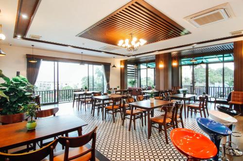 a restaurant with tables and chairs and windows at Sea Angel Hotel Halong in Ha Long