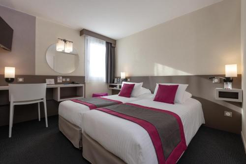 Un pat sau paturi într-o cameră la Kyriad Hotel Lyon Givors