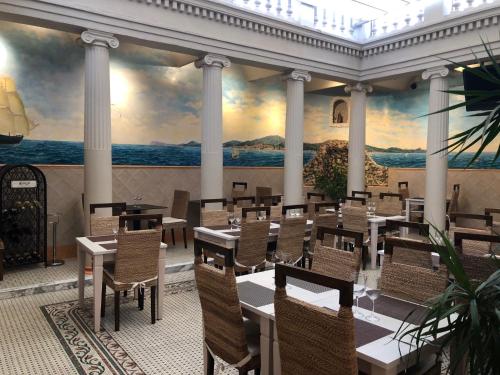 a restaurant with tables and chairs and a mural at Llar de Capitans in Masnou