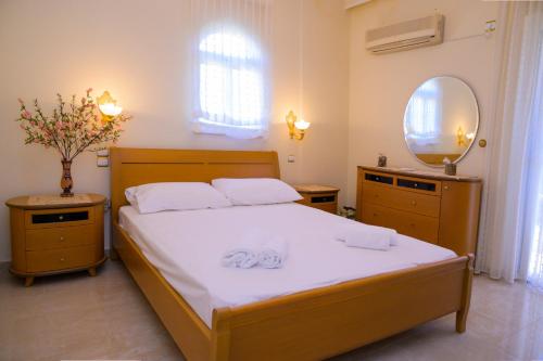 a bedroom with a bed with two towels on it at GREEN PARADISE PALAIA FoKAIA in Áyios Yeóryios