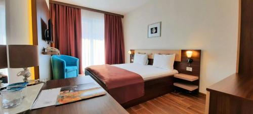 a hotel room with a bed and a desk at Hotel DOA in Skopje