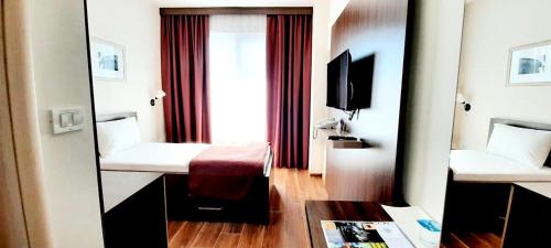 a hotel room with a bed and a mirror at Hotel DOA in Skopje