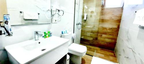 a bathroom with a toilet and a sink and a shower at Hotel DOA in Skopje