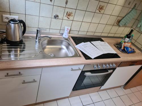 a kitchen counter with a sink and a stove at Ferienwohnung Fellnasen WG 2 in Krefeld