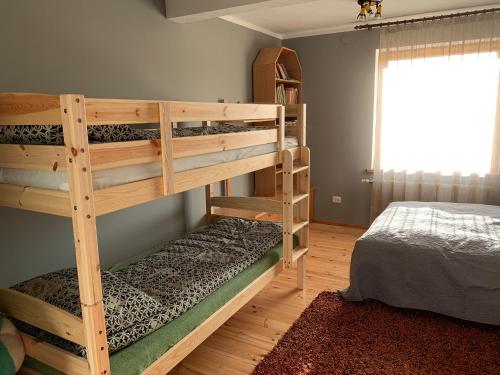 two bunk beds in a room with a bed at Hostel Kastaņas in Lielvārde