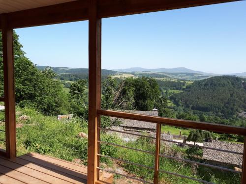 Una habitación con vista a las montañas desde un balcón. en Auberge & Camping Sabatoux, en Montusclat