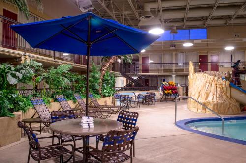 a table with a blue umbrella next to a pool at Holiday Inn Fargo by IHG in Fargo