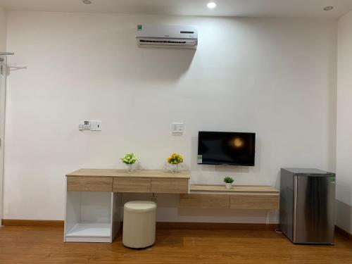 a desk with a tv on a white wall at Khải Hoàn Luxury Hotel in Bến Cát