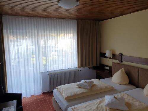 a hotel room with two beds and a window at Kurparkhotel-Gemünd in Gemünd